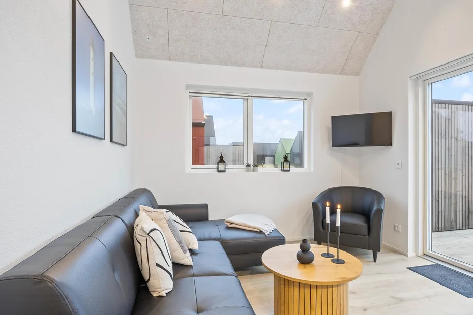 Una sala luminosa con asientos, una mesa de centro y una ventana.