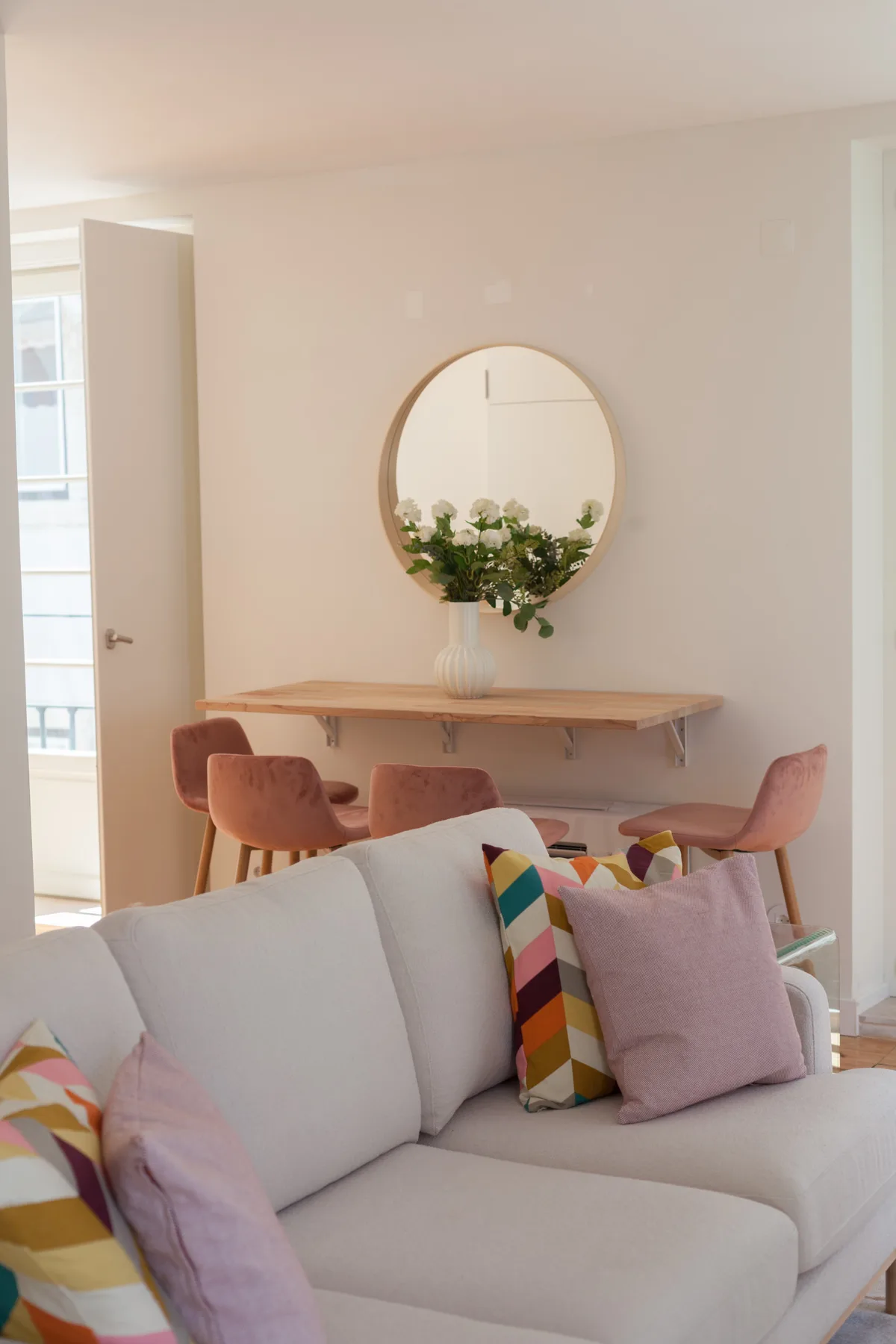 Living room with a light-colored sofa and a dining area behind it.