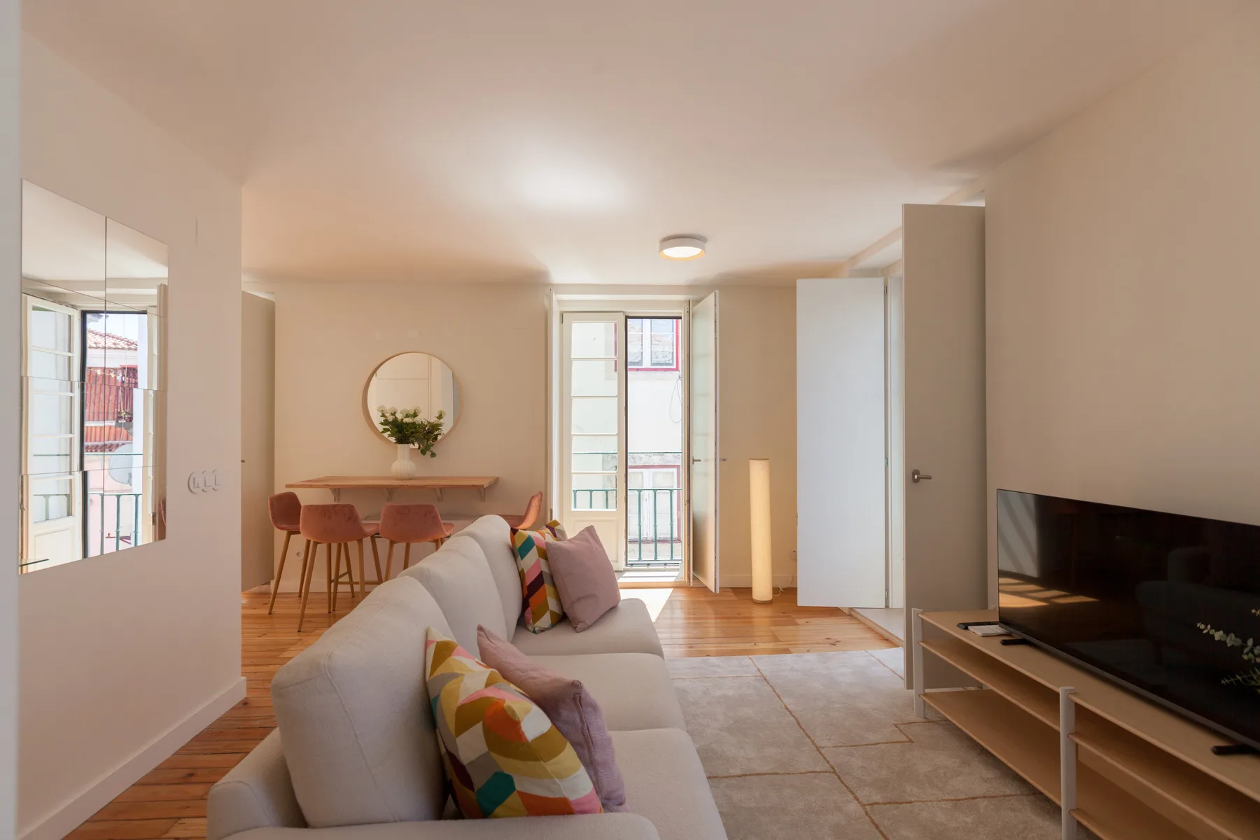 Living room with seating, a dining table, and a television.