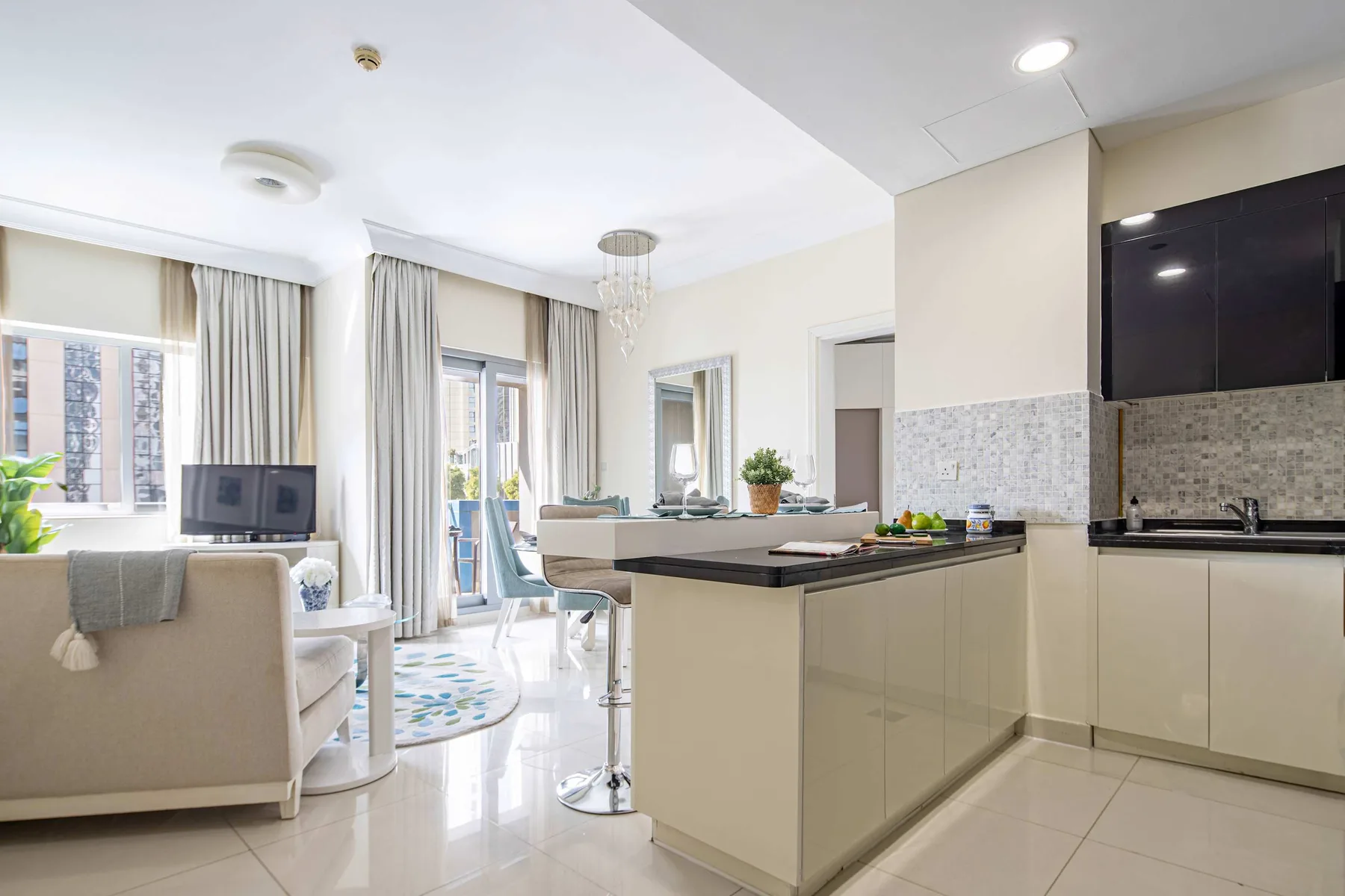 Sala de estar y cocina de concepto abierto, con una isla y grandes ventanas.