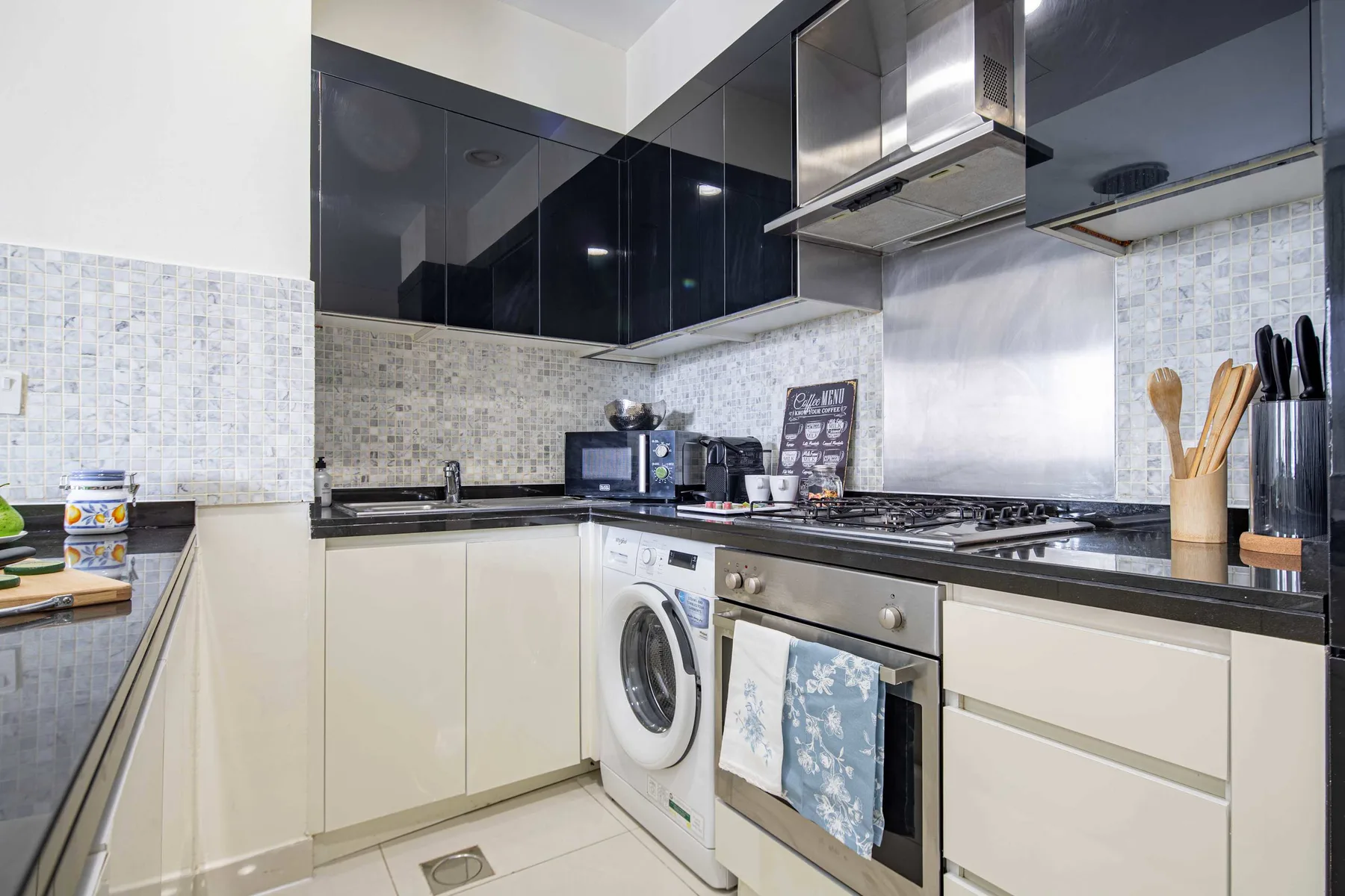 Una cocina moderna con gabinetes oscuros, encimera y electrodomésticos integrados.