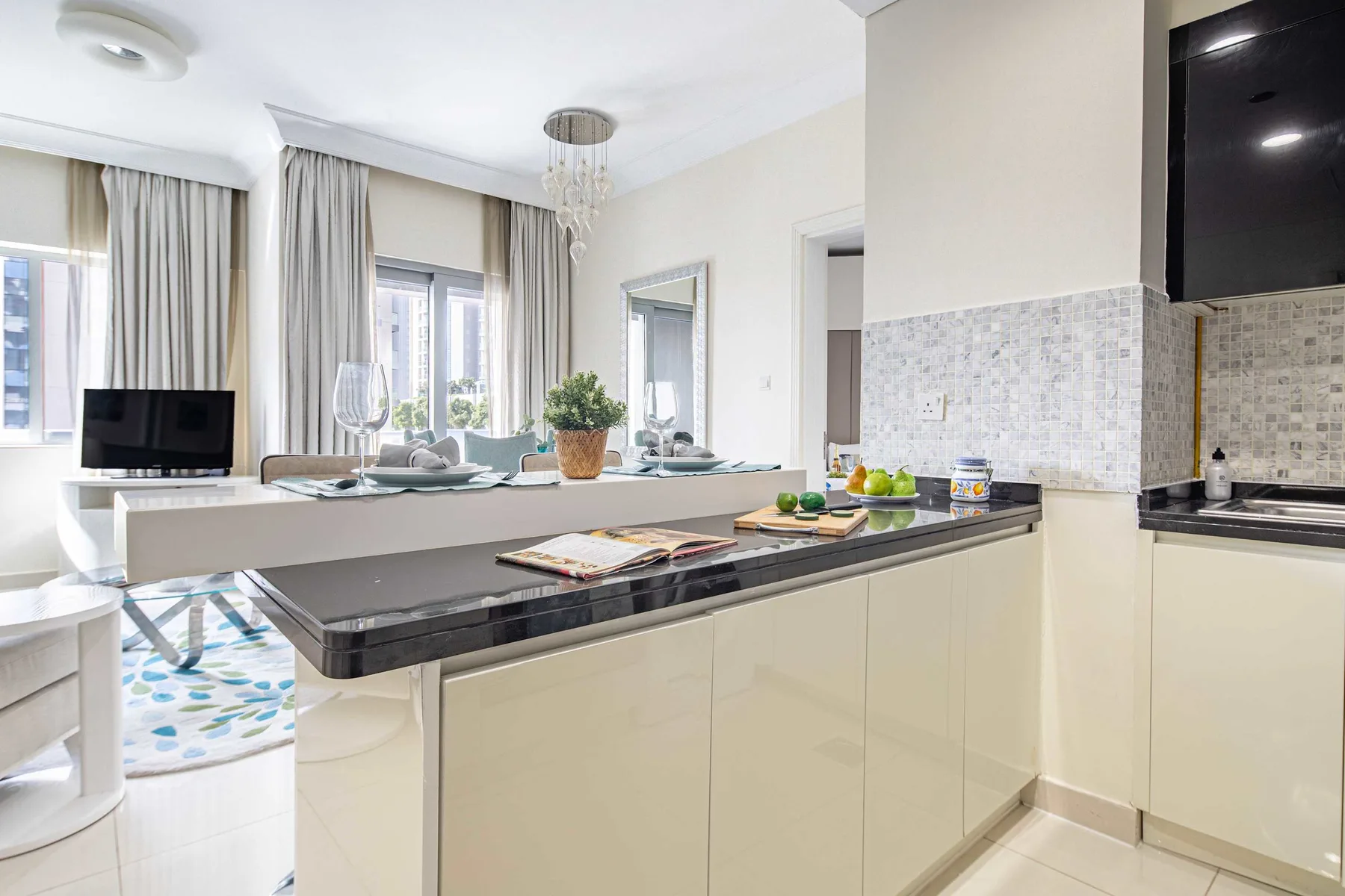 Una cocina y comedor luminosos de concepto abierto, con una isla larga y ventanas altas.
