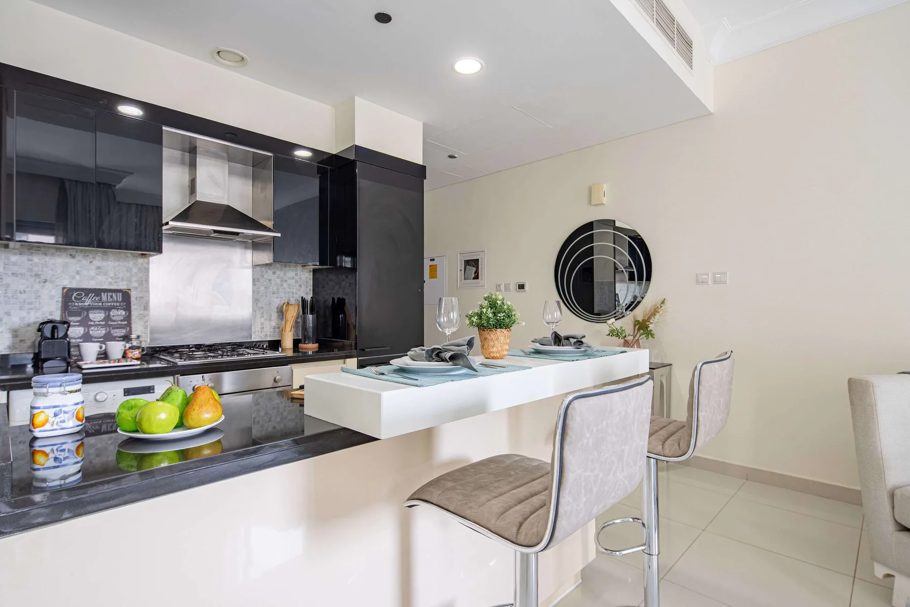 Una cocina moderna con una isla blanca y gabinetes oscuros.