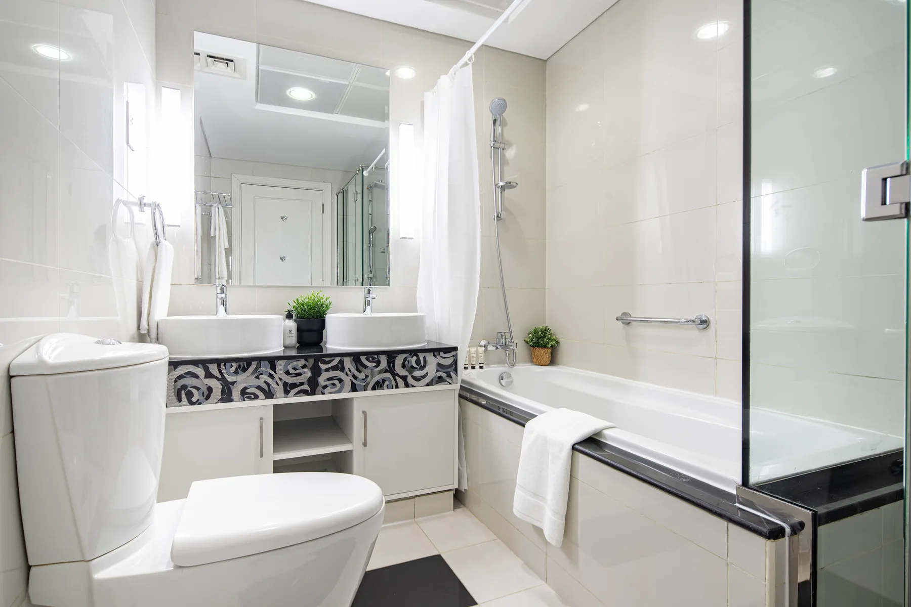 Un baño luminoso con bañera, ducha, lavabo e inodoro.