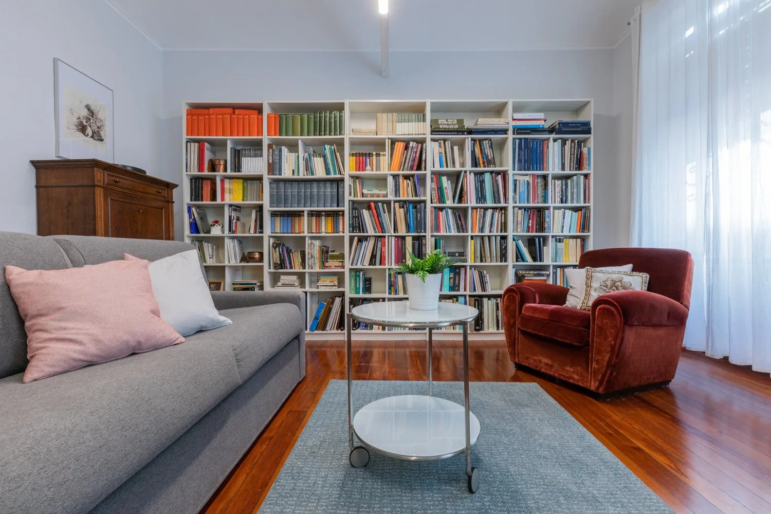 A living room with bookshelves, seating, and a small round table.