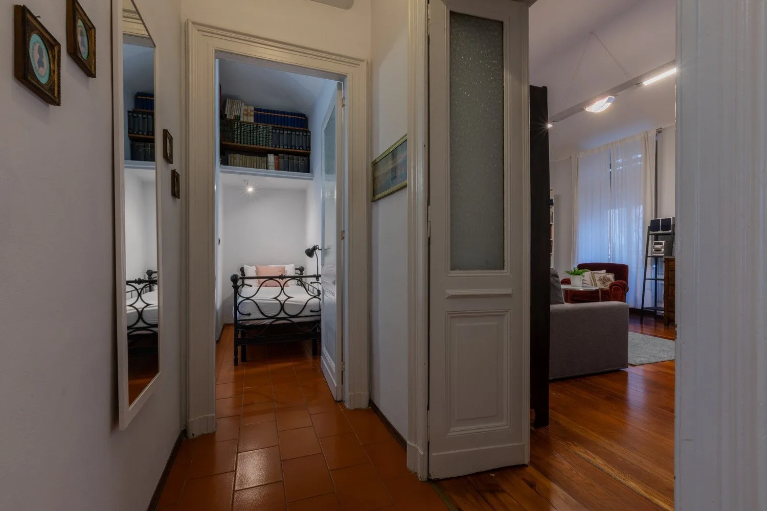 A hallway opens onto a bedroom and a living area.