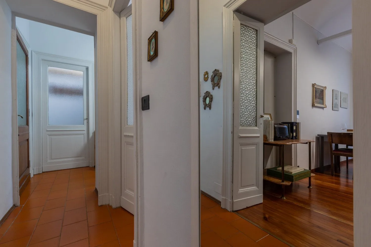 A hallway opens into a dining area with a table and chairs.