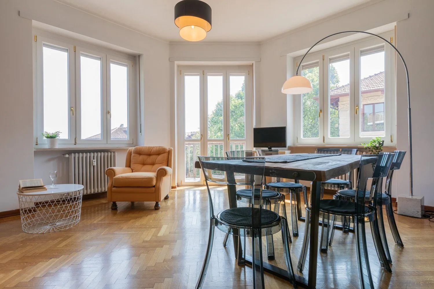 Un comedor luminoso con una mesa larga y grandes ventanas.