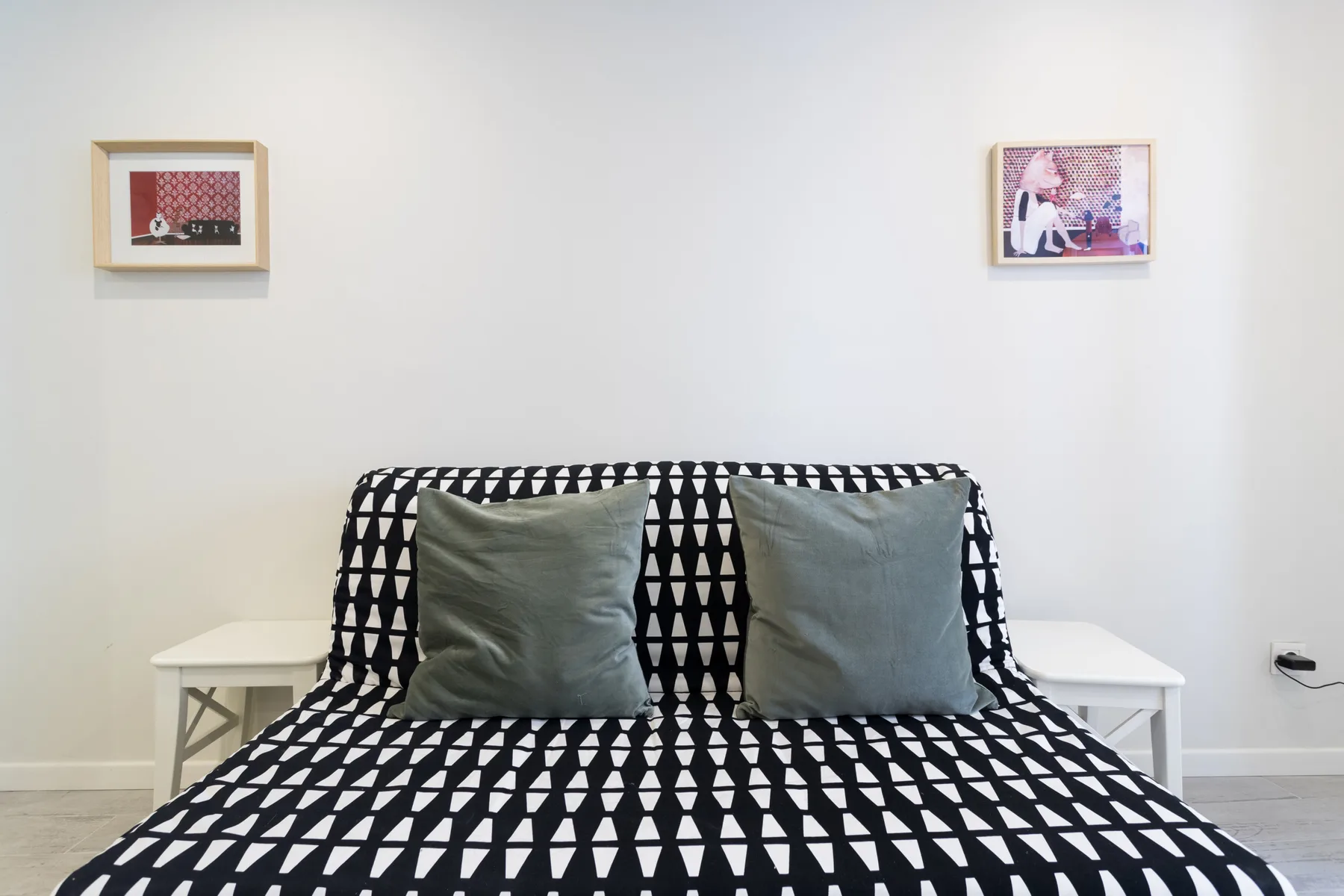 A bedroom scene with a bed covered in a black-and-white geometric pattern.