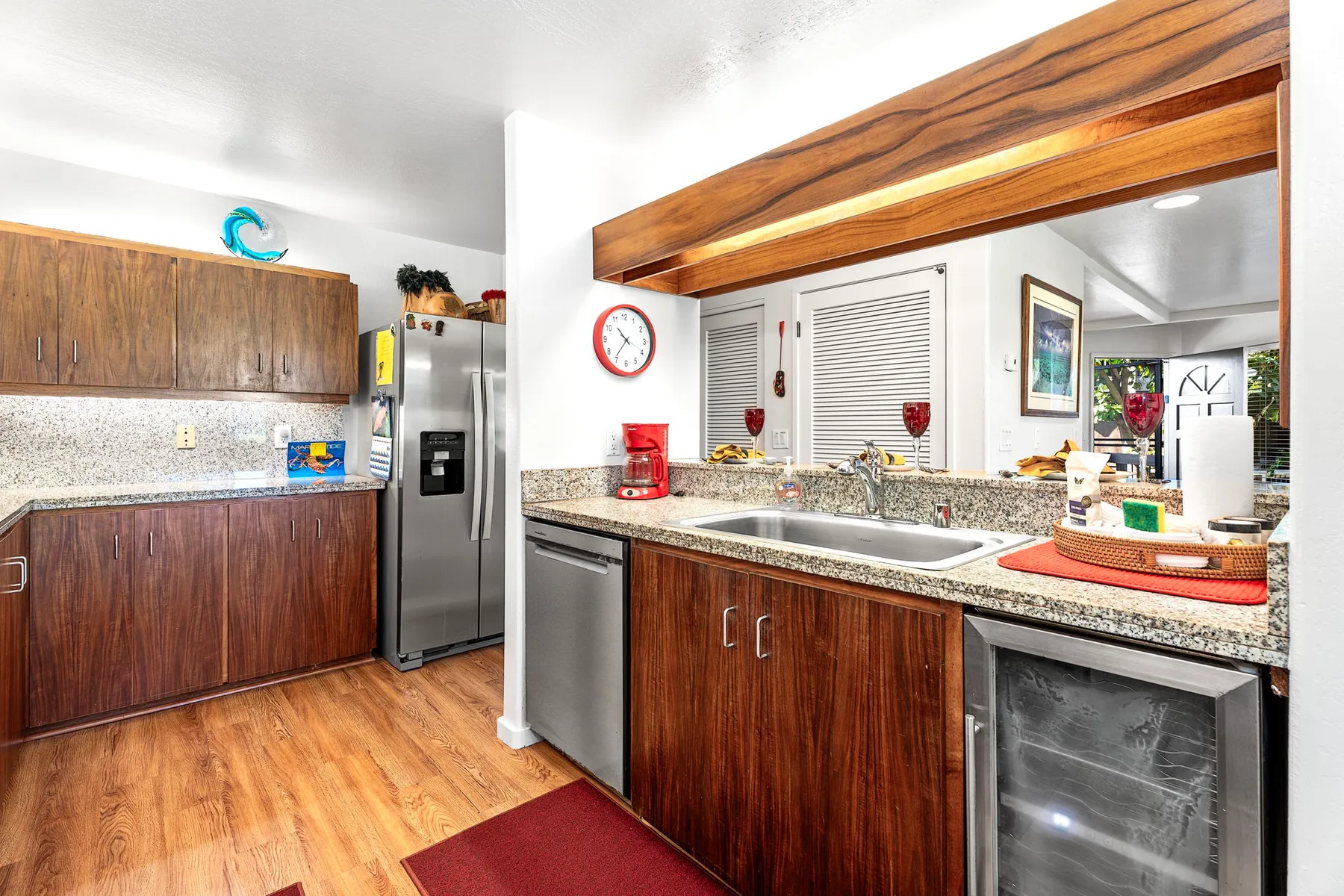 A kitchen with a countertop, sink, and stainless steel refrigerator.