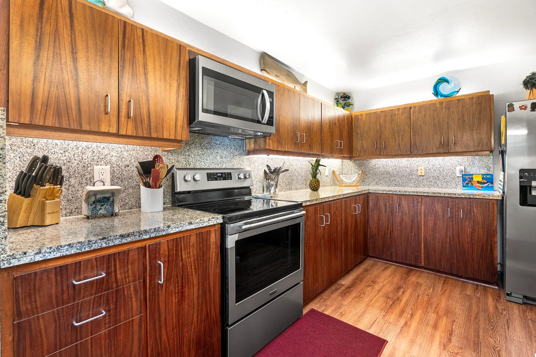 A kitchen with wood cabinets, a stove, and a countertop.