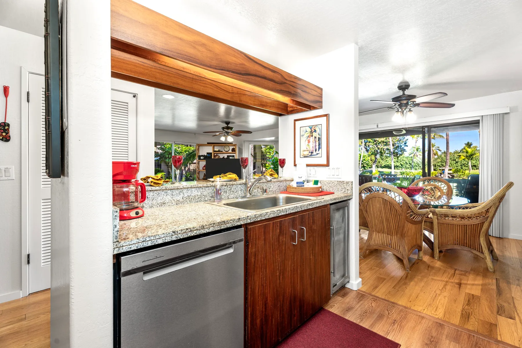 An open kitchen and dining area with a granite counter and wicker seating.