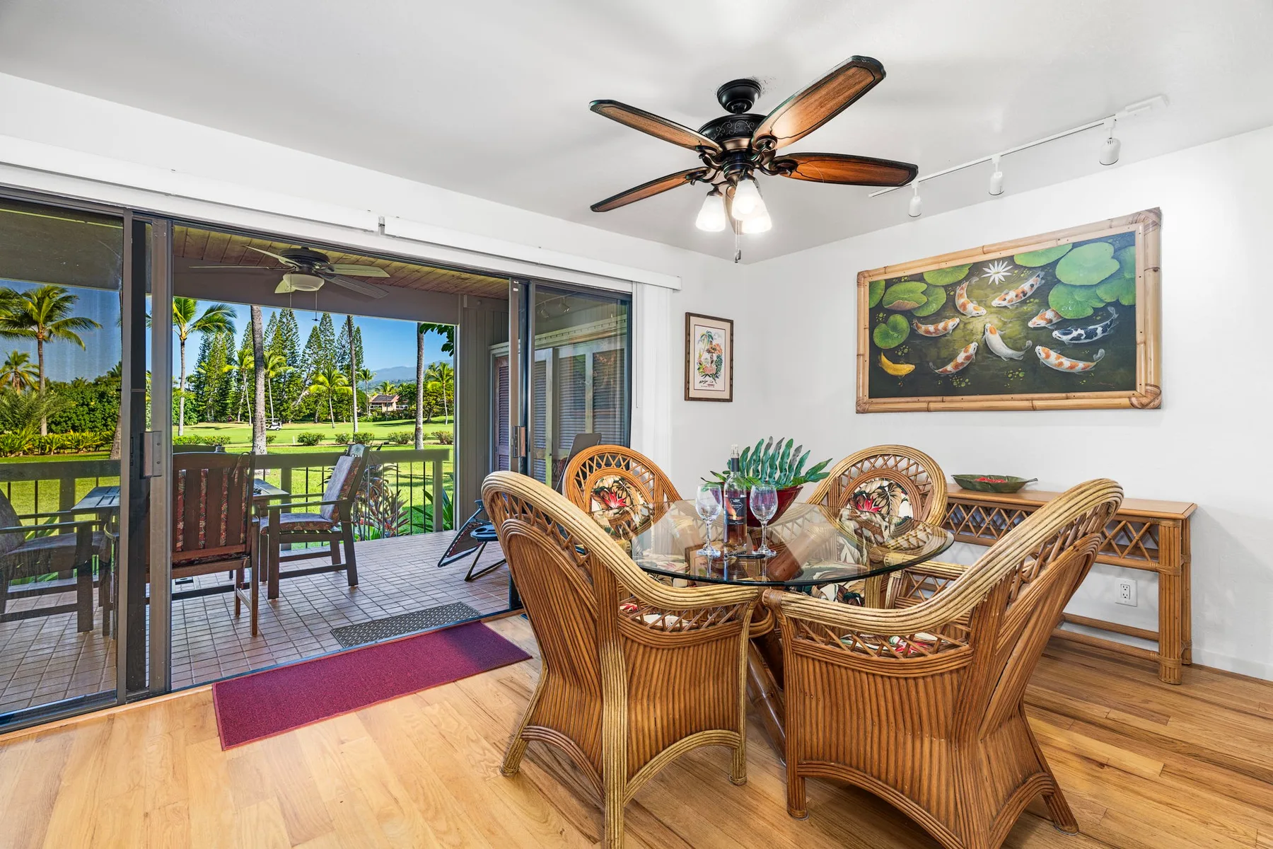 A dining area with woven seating and glass doors opening onto a patio.