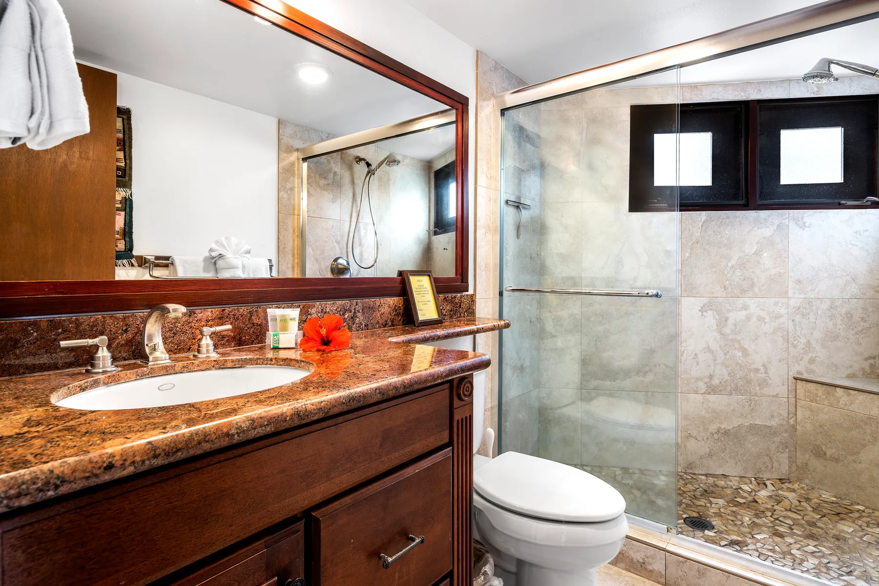 Un baño con lavabo, espejo y ducha de vidrio.