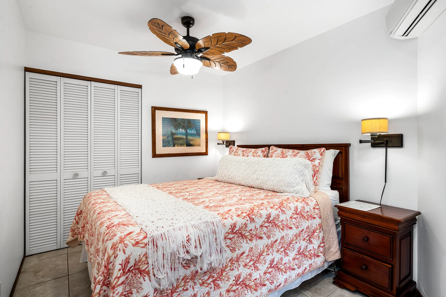 Un dormitorio con una cama cubierta con una colcha de estampado floral.