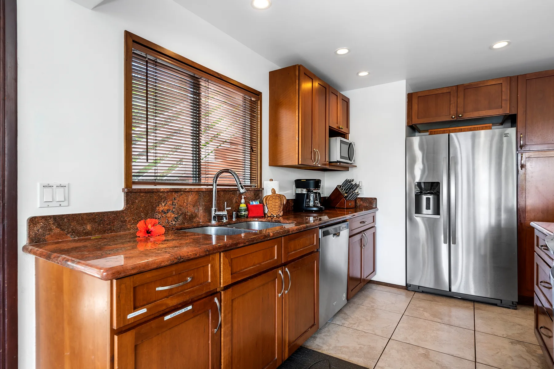 Una cocina con gabinetes de madera, una encimera y un refrigerador de acero inoxidable.
