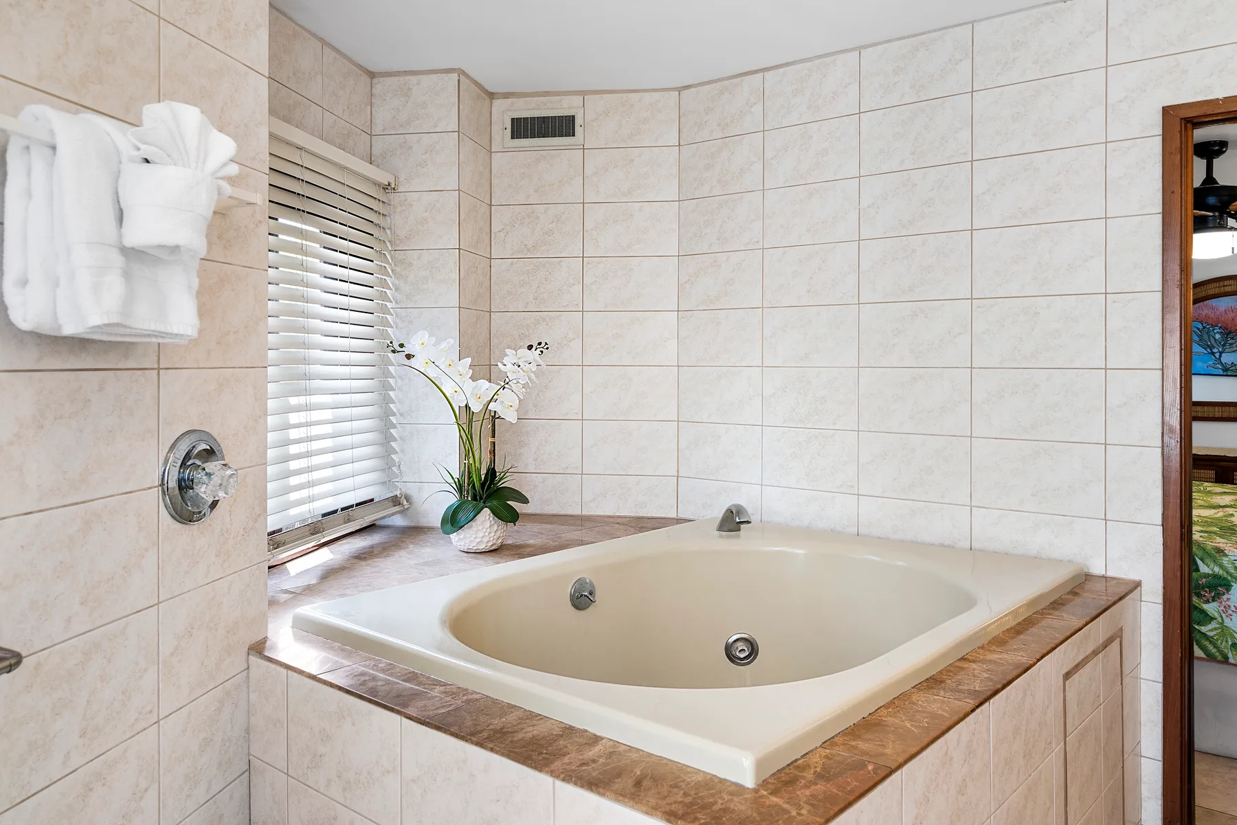Un baño con azulejos y una bañera empotrada junto a una ventana.