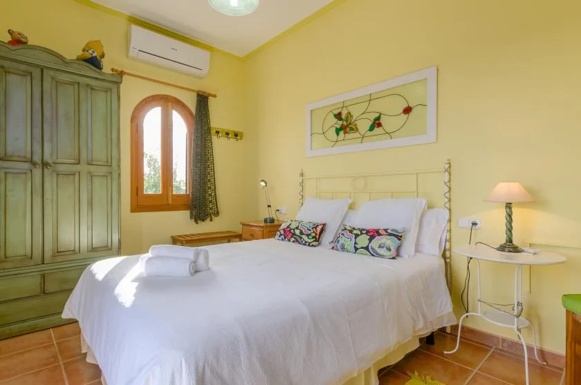 Un dormitorio con una cama bien hecha y un armario grande.