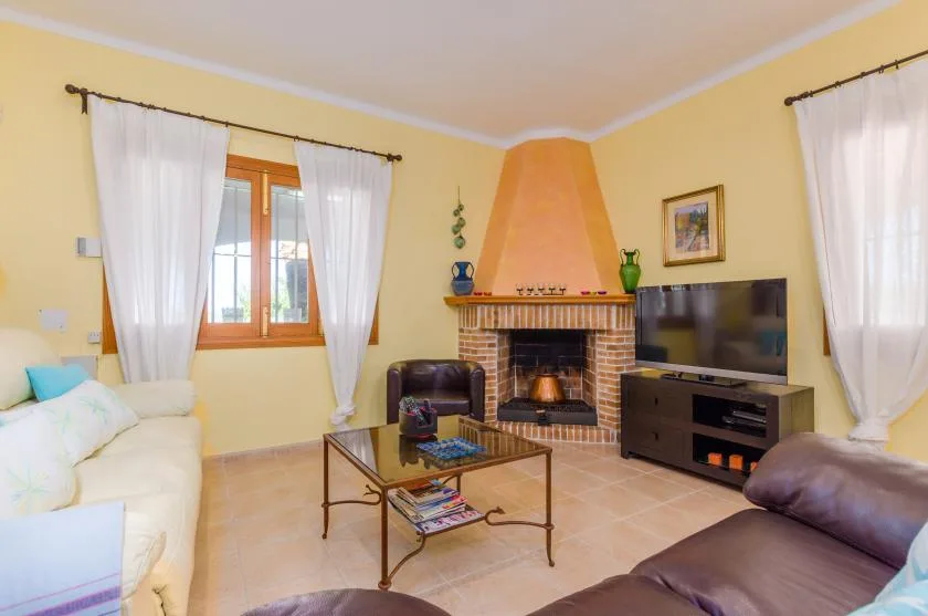 Una sala de estar con asientos, una chimenea y un televisor.
