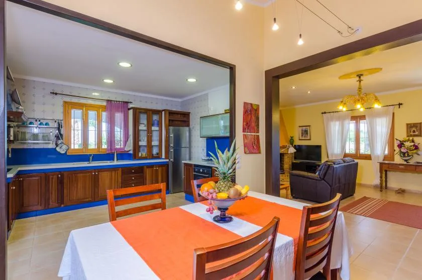 Un comedor con un camino de mesa naranja se abre a la cocina y la sala de estar.