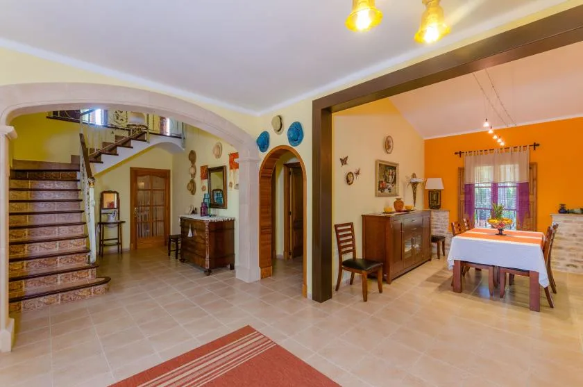 Un comedor con una mesa y sillas junto a una escalera.