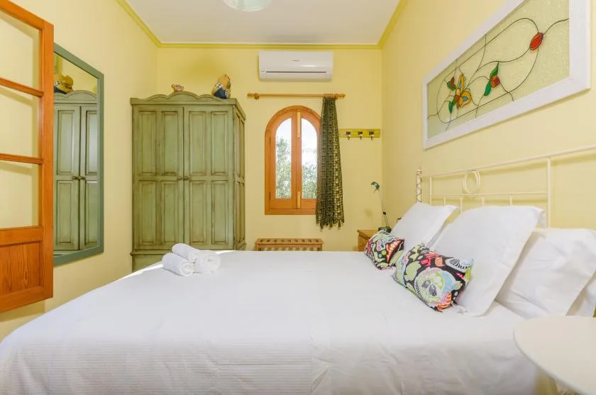 Un dormitorio luminoso con una cama grande y un armario alto.