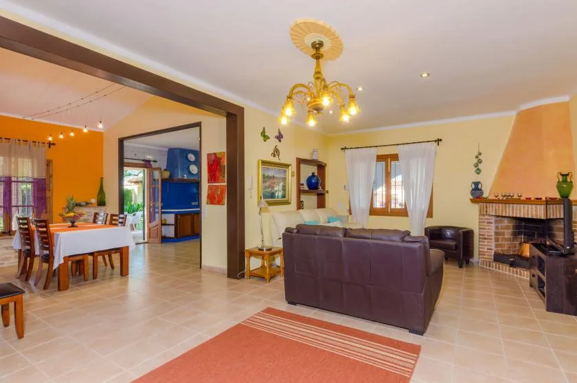 Una sala de estar y comedor con sofá, mesa de comedor y chimenea.