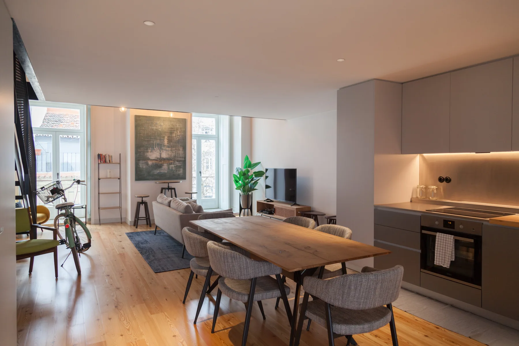 Open-plan living and dining area with a kitchen, table, and seating.