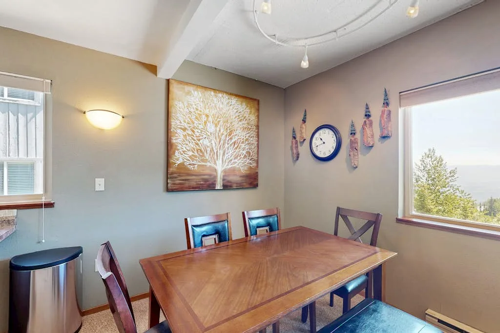 A dining area with a wooden table, seating, and wall art.
