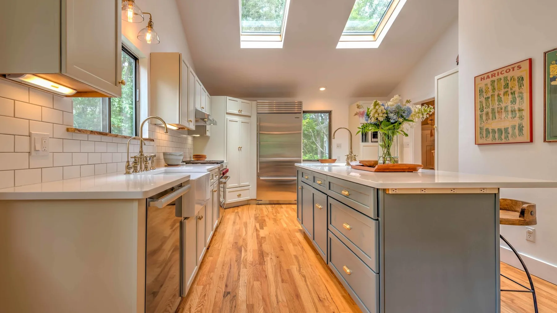 A bright kitchen with a central island and skylights.