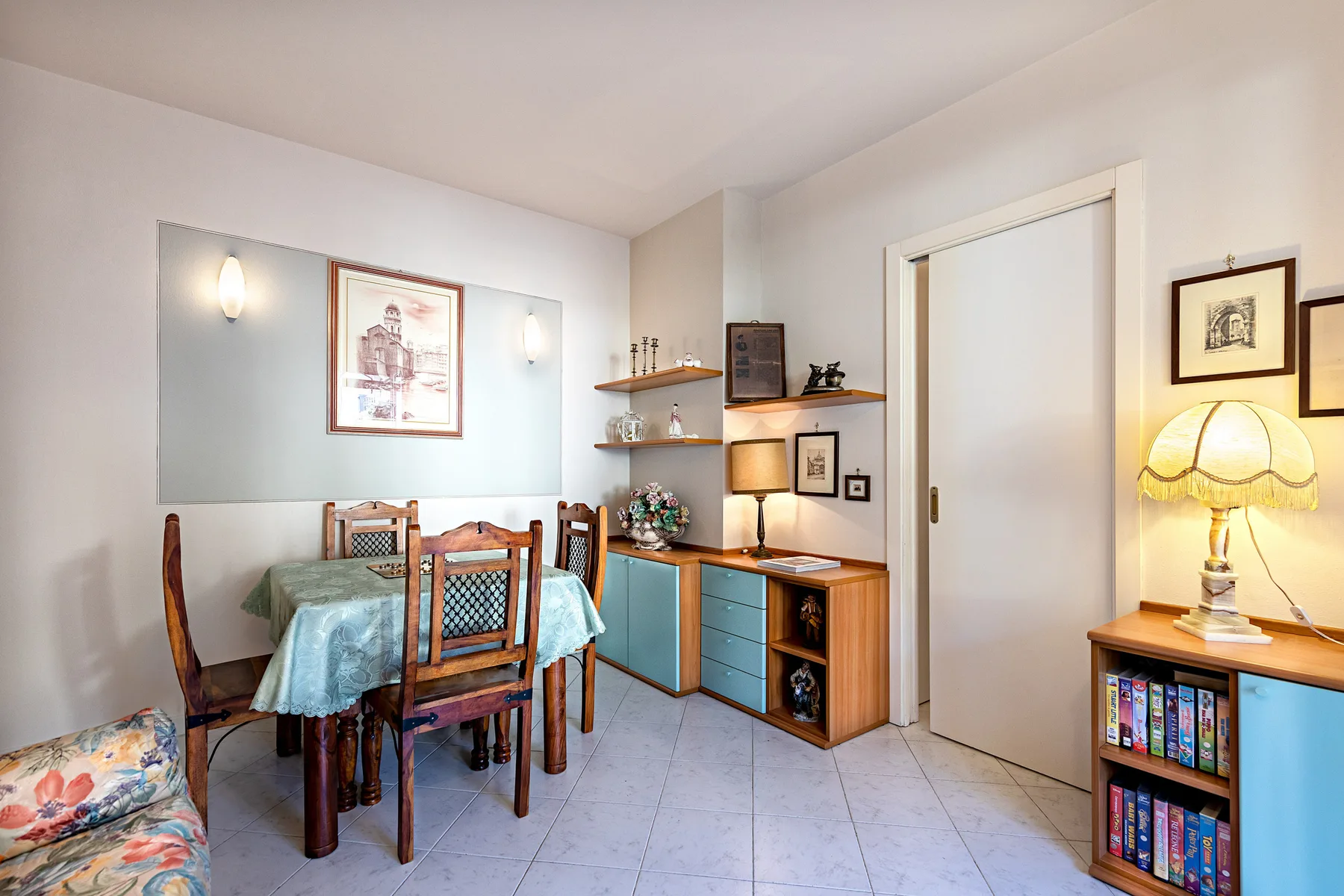 A dining area with a table and chairs beside built-in shelving.