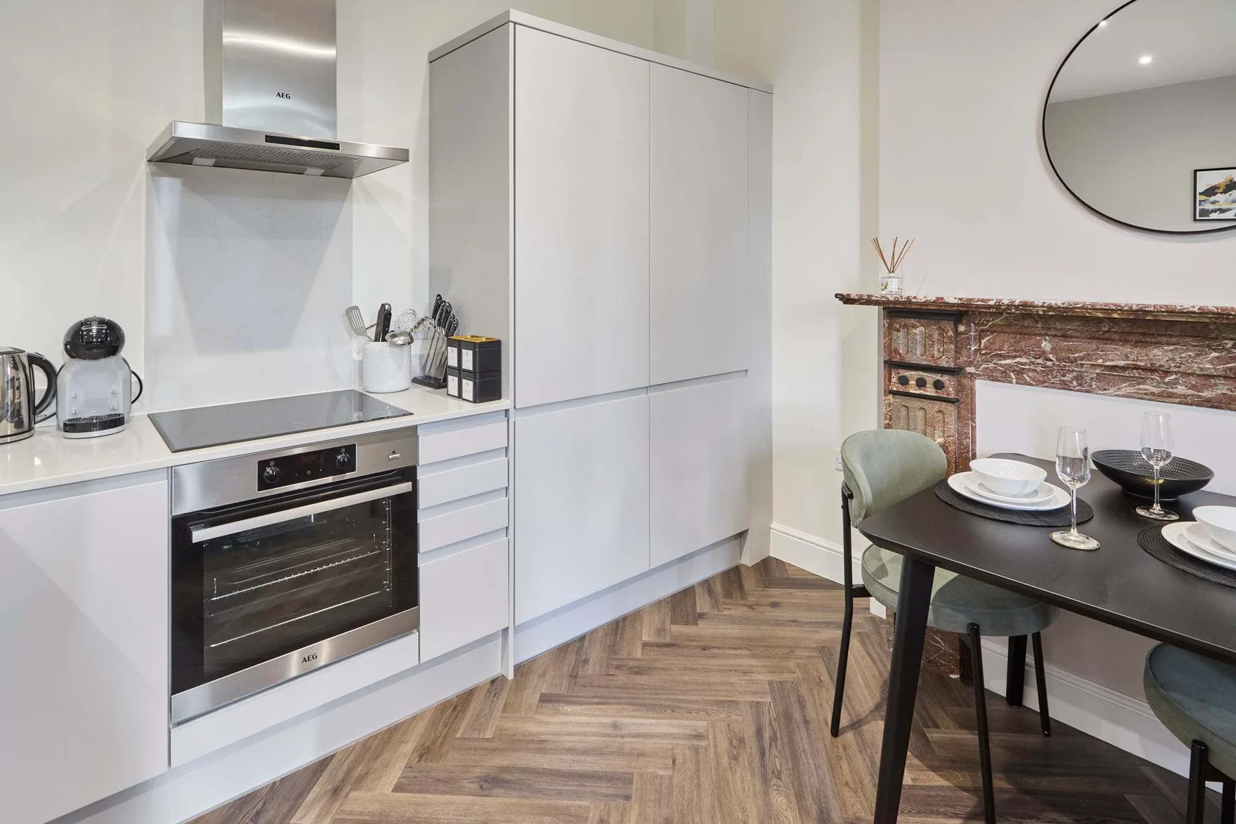 A modern kitchen and dining area with white cabinets and a dark table.