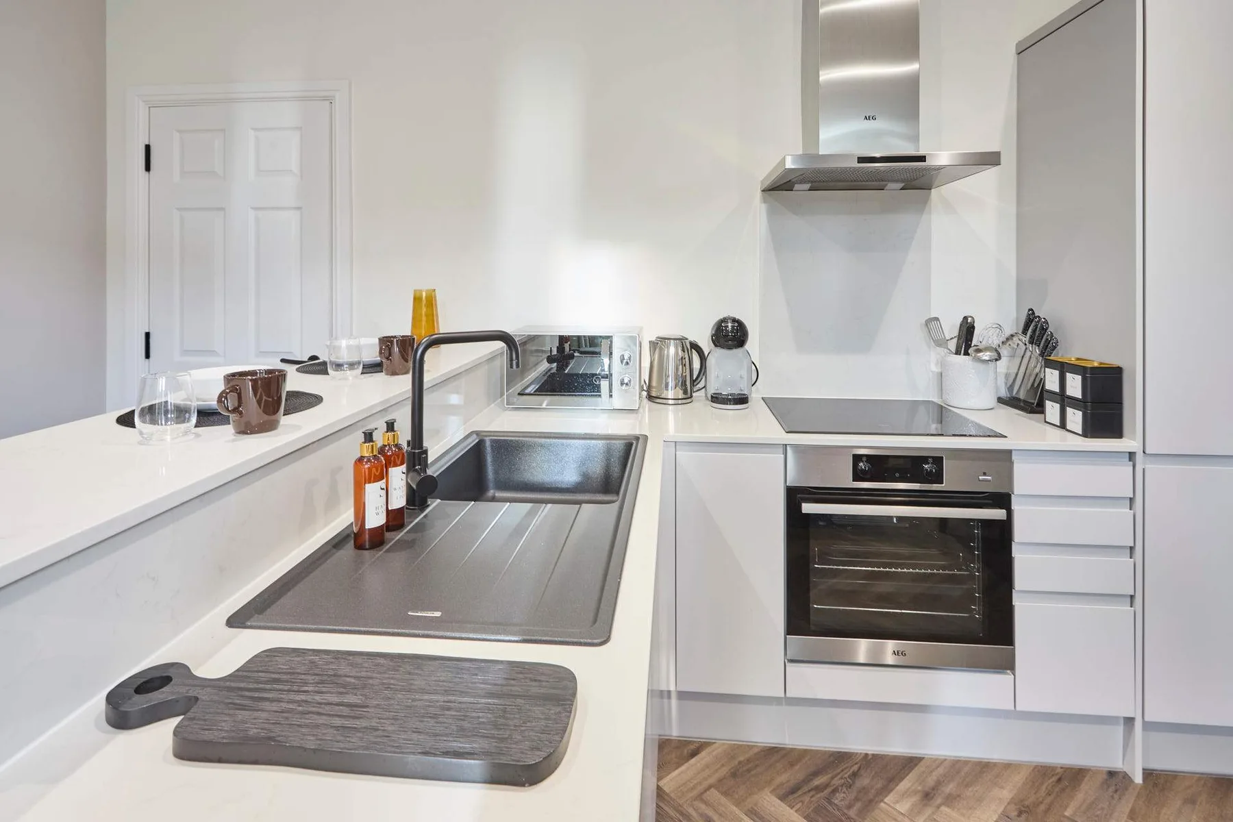 A bright modern kitchen with white cabinets and stainless steel appliances.