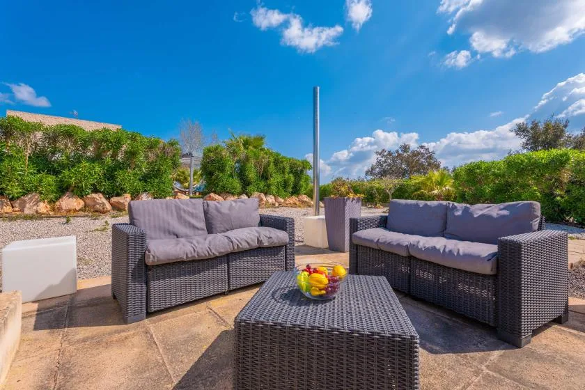 An outdoor patio seating area with cushioned furniture and a low table.