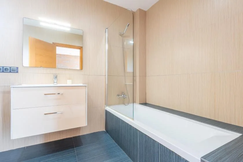 A bathroom with a bathtub, shower, and vanity.