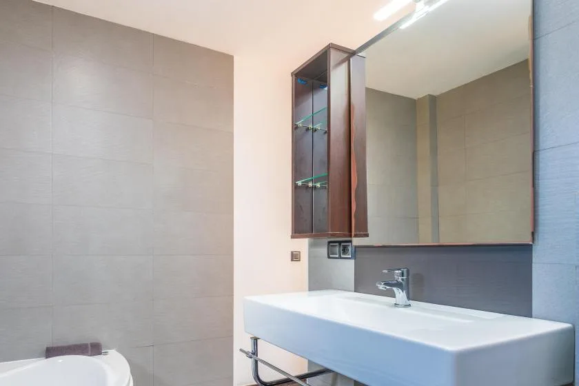 A modern bathroom with a wide sink and large wall mirror.