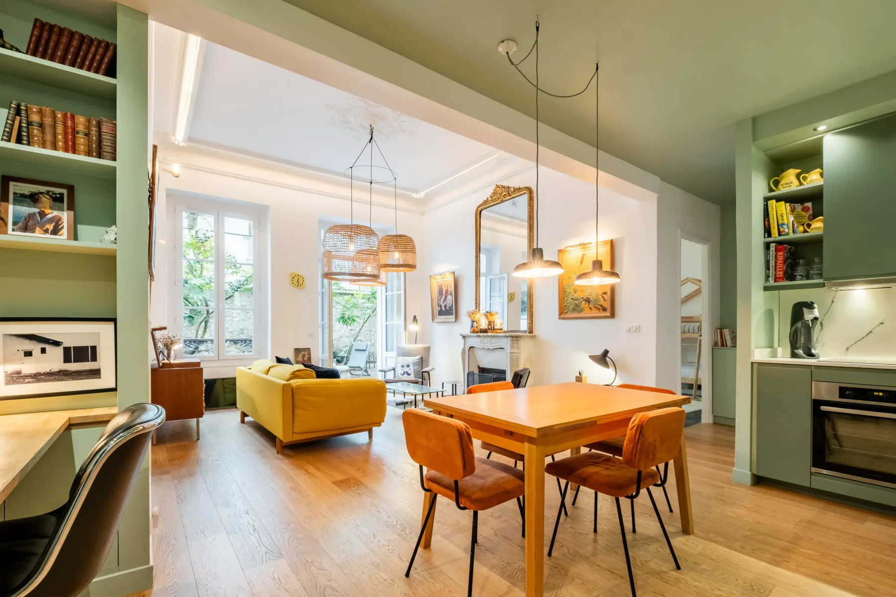 A bright living and dining room with a wooden table and seating.