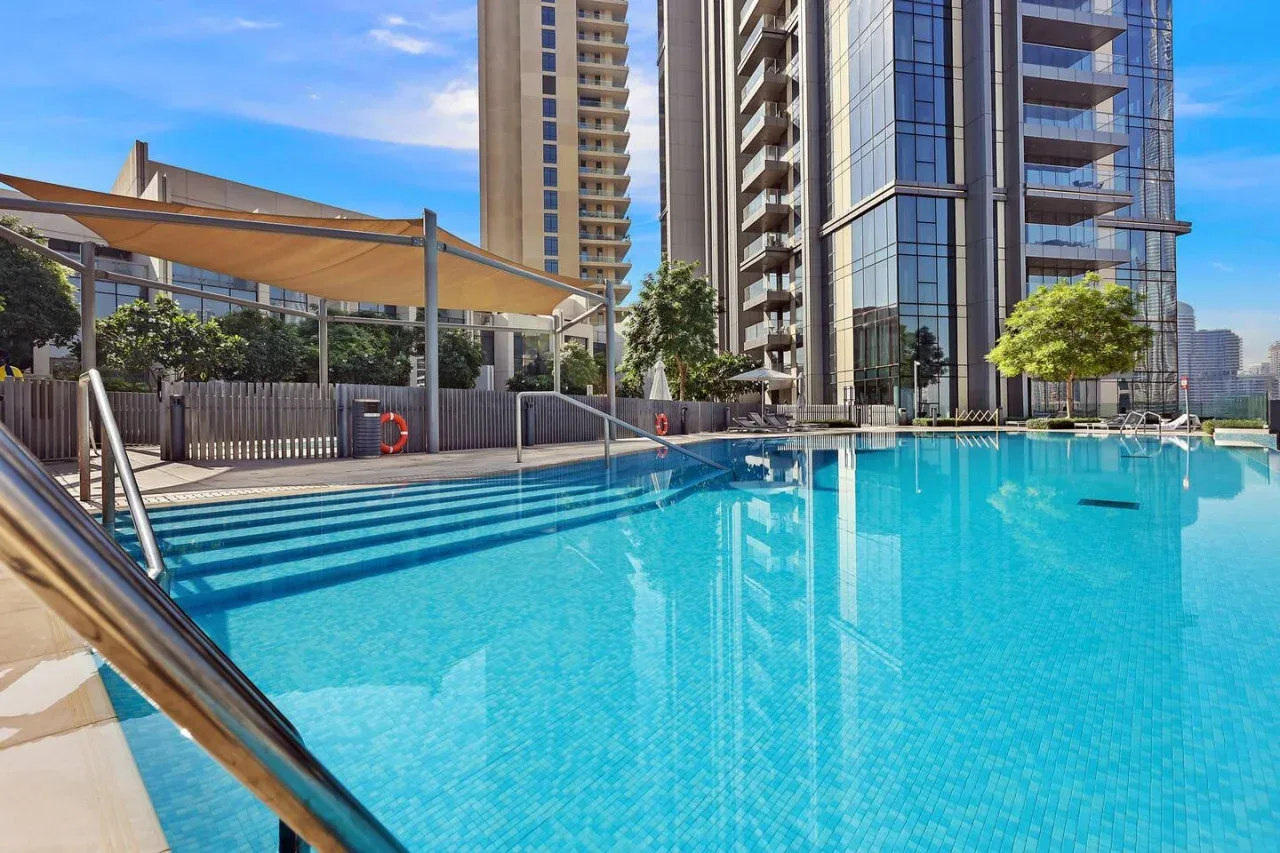 Una piscina en la azotea junto a modernos edificios altos.