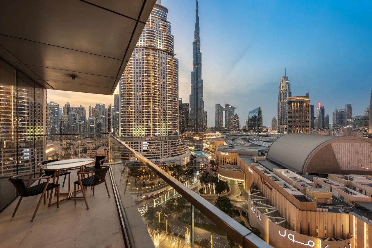 Un balcón ofrece vistas del horizonte urbano con una torre muy alta en el centro.