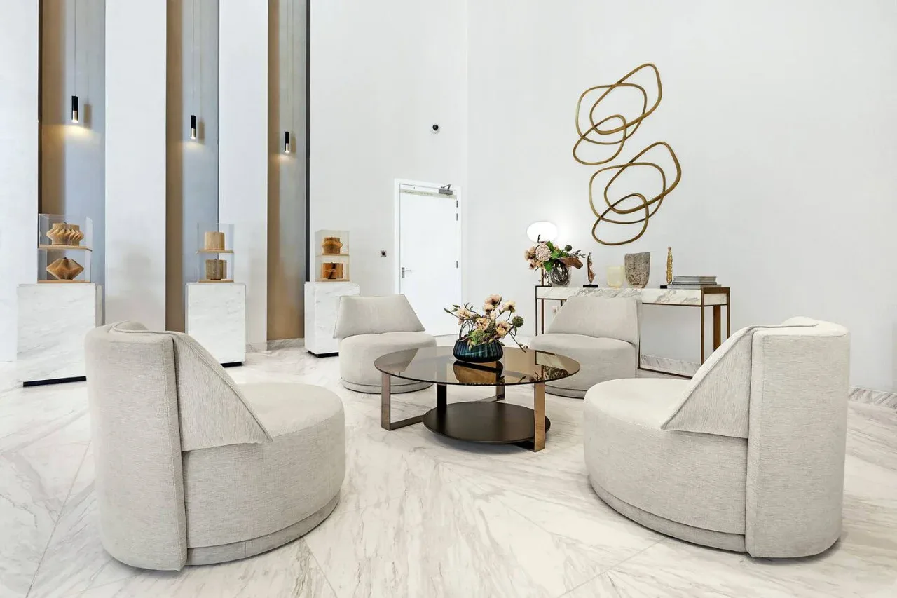 Una sala luminosa con asientos curvos y una mesa de centro de vidrio.