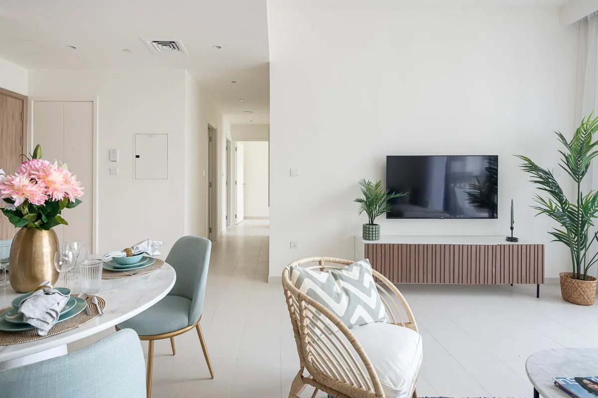 A bright living and dining area with a television and dining table.