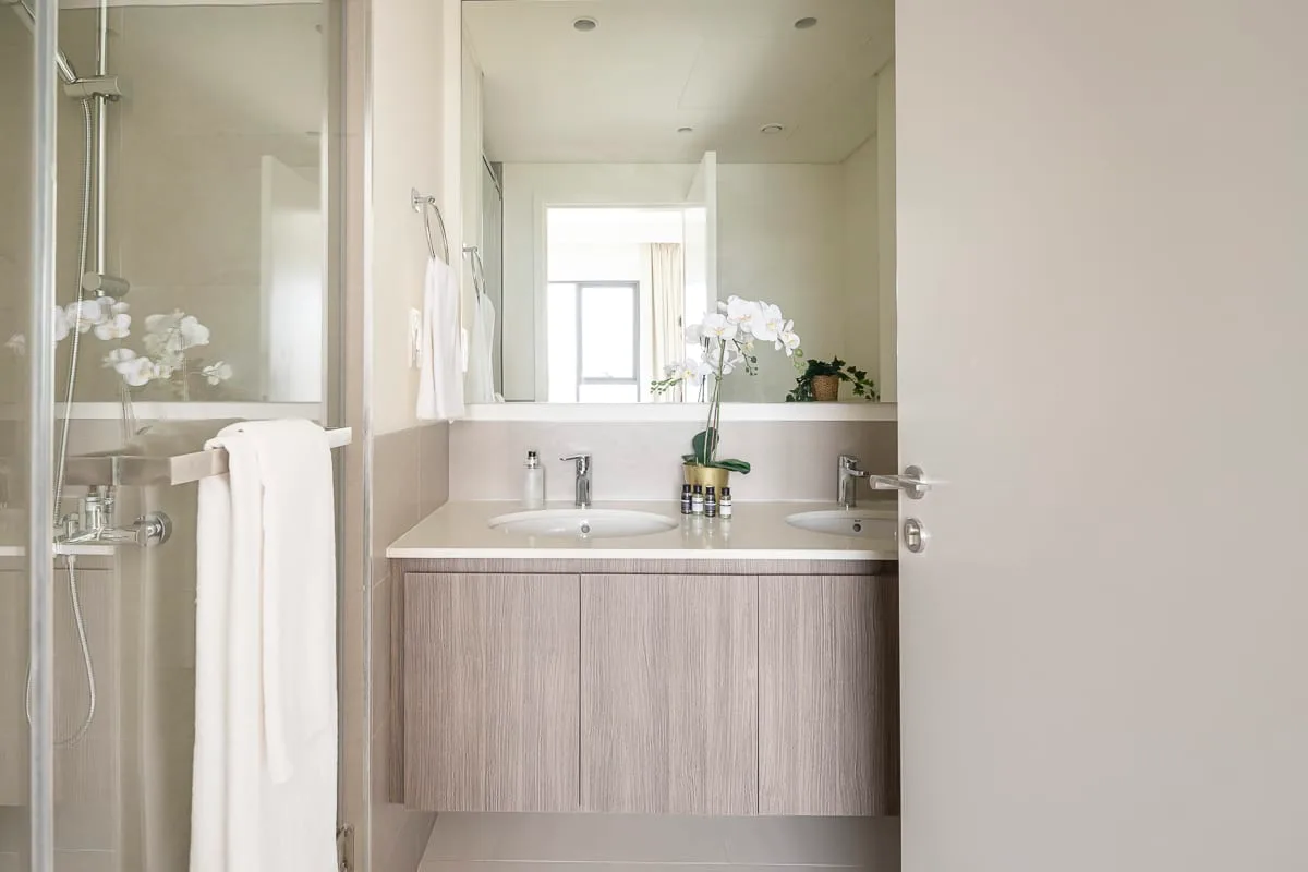 Un baño luminoso con mueble de lavabo y espejo.