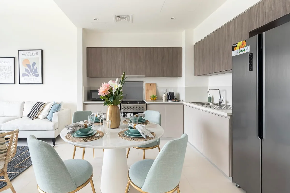 Una cocina-comedor de planta abierta con la mesa puesta y una zona de estar contigua.