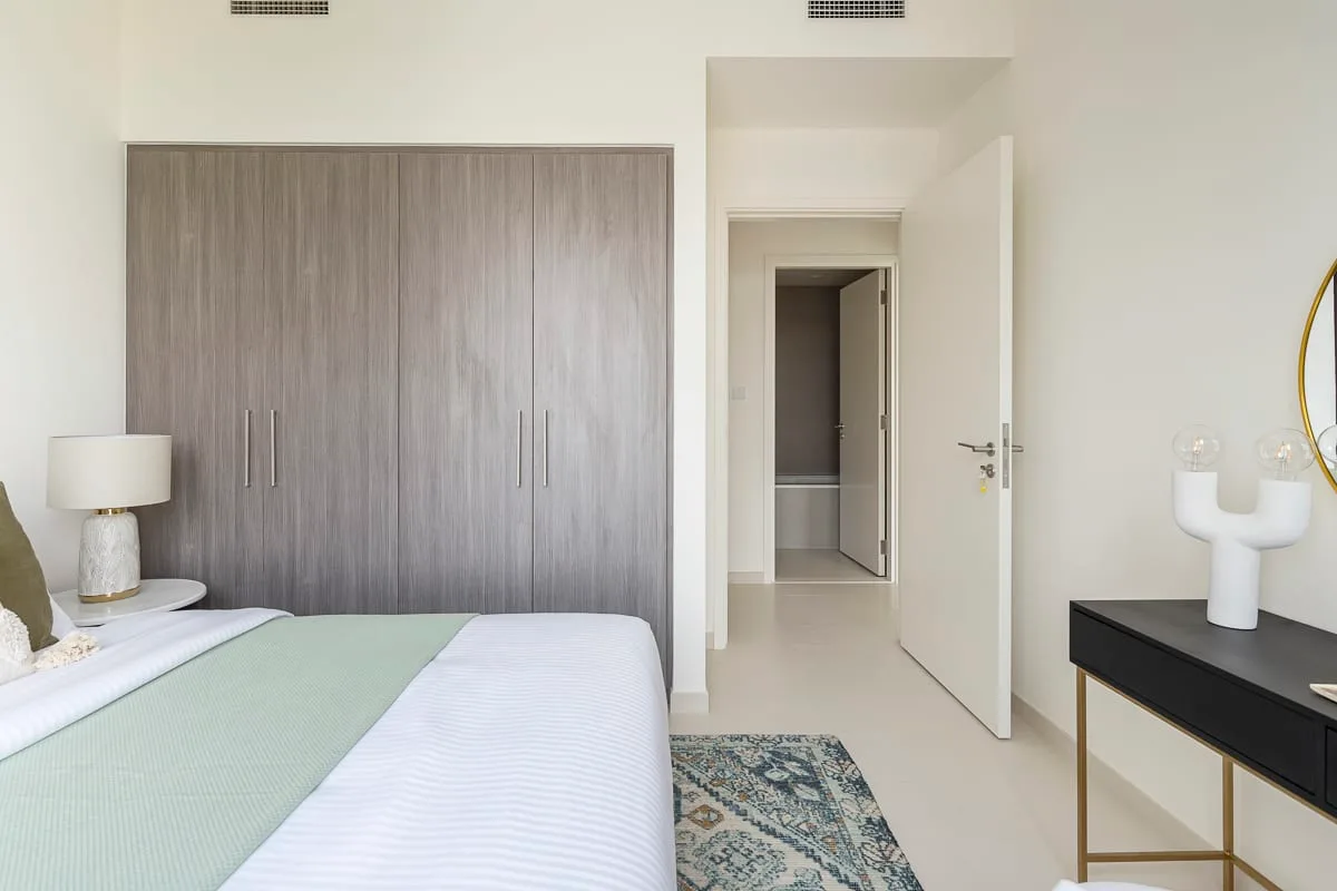 Un dormitorio con una cama, un armario grande y una puerta abierta.