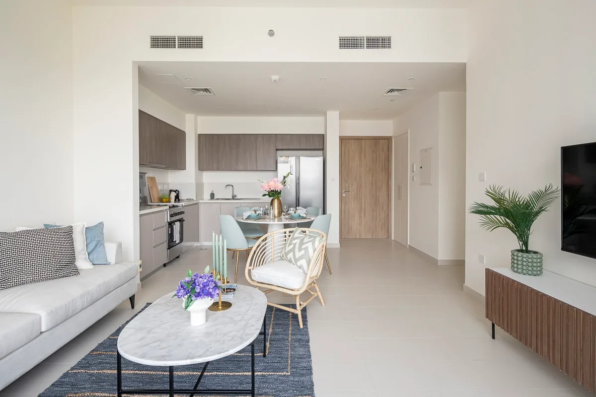 A bright living and dining area with a kitchen, seating, and a dining table.