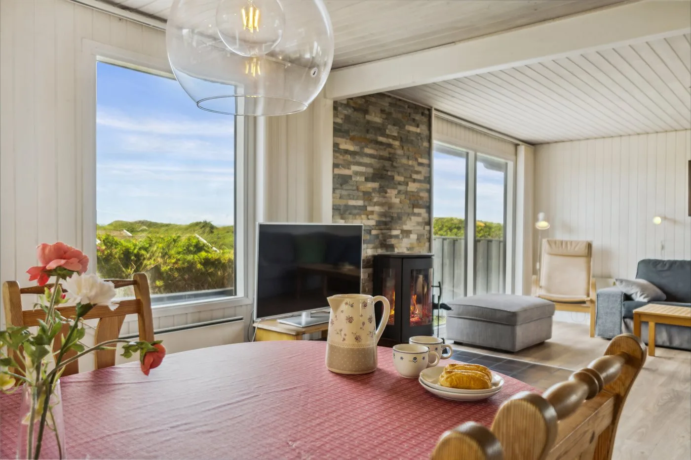 Una sala de estar con asientos, televisor y mesa de comedor.