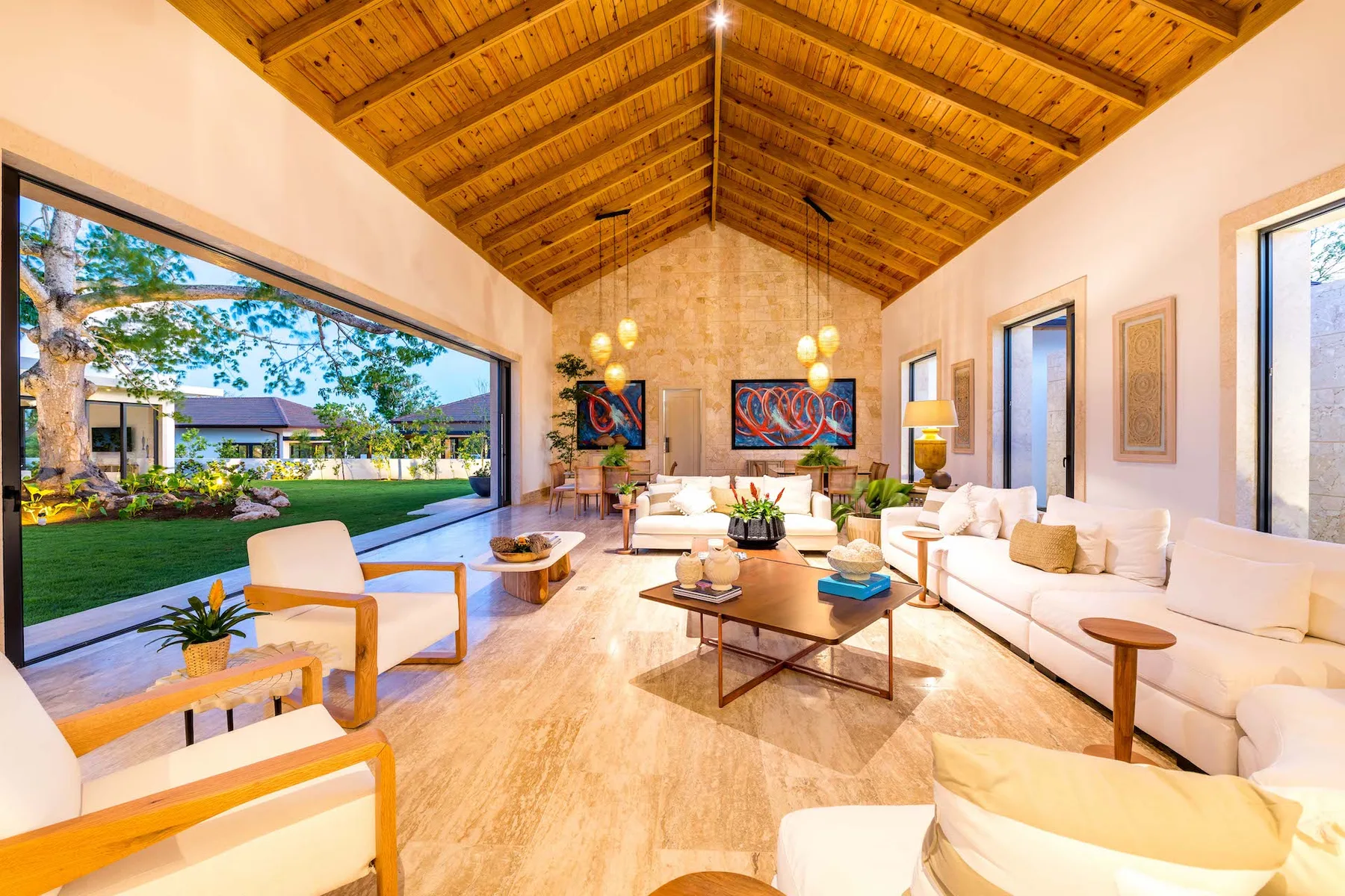 Una sala luminosa se abre a un jardín a través de un amplio ventanal.