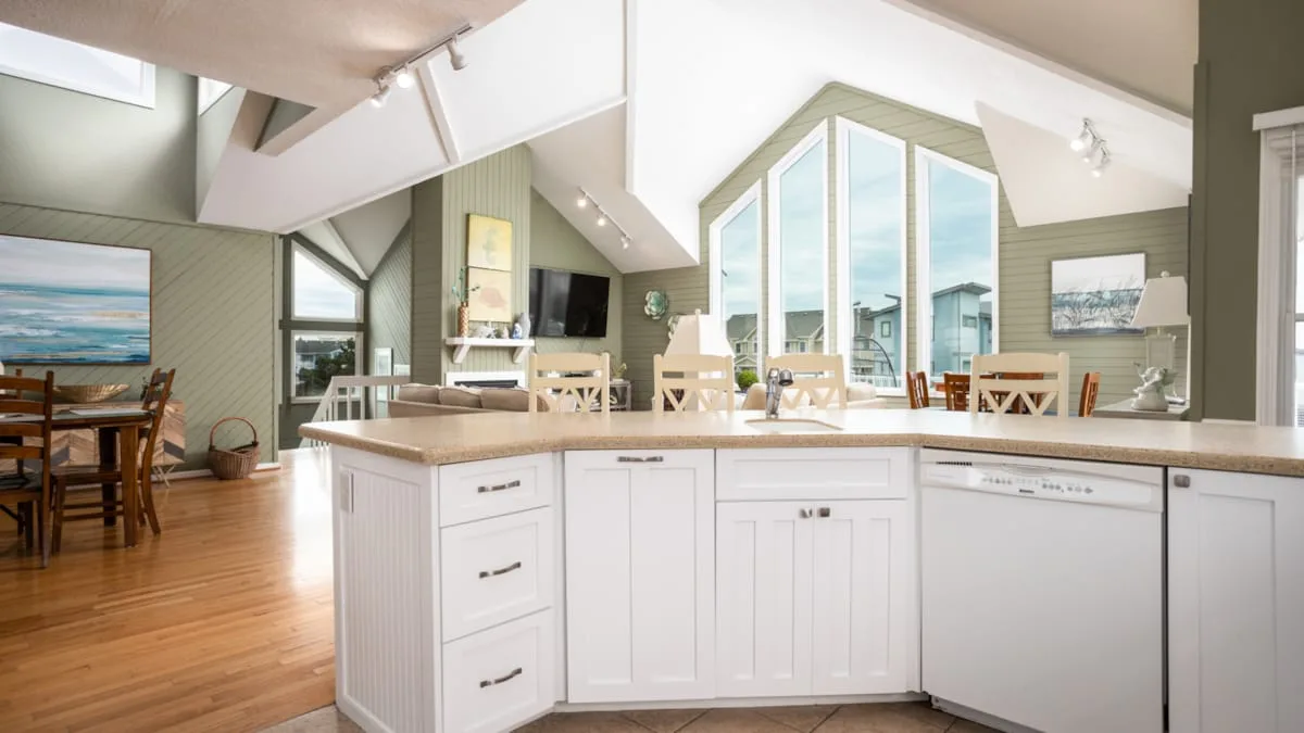 Una cocina luminosa con una isla grande y ventanas altas.