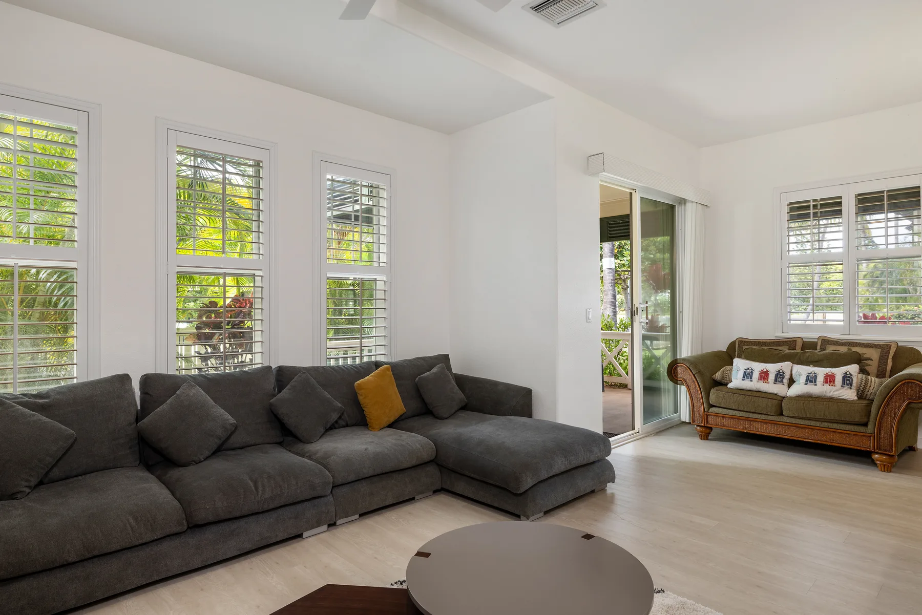 Una sala luminosa con un sofá seccional grande y ventanas.