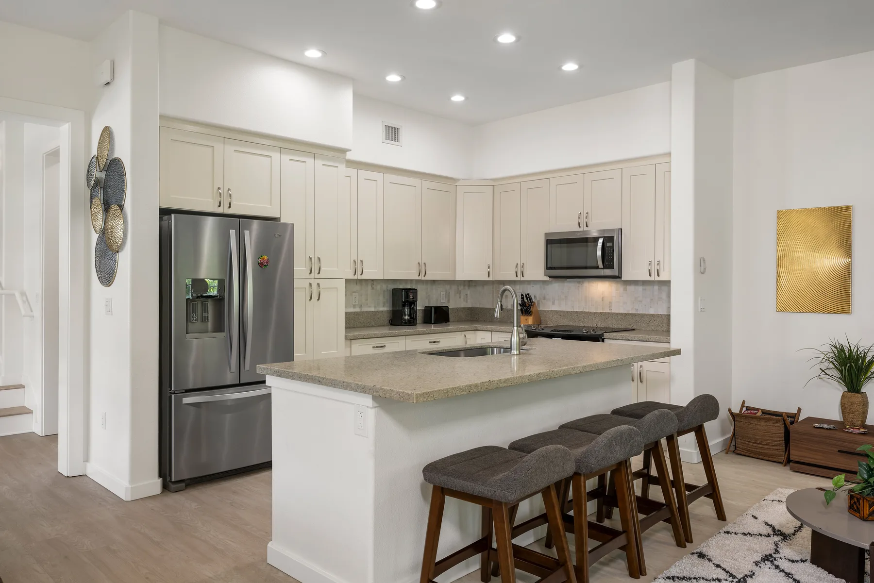 Una cocina moderna y luminosa con una gran isla y asientos de barra.